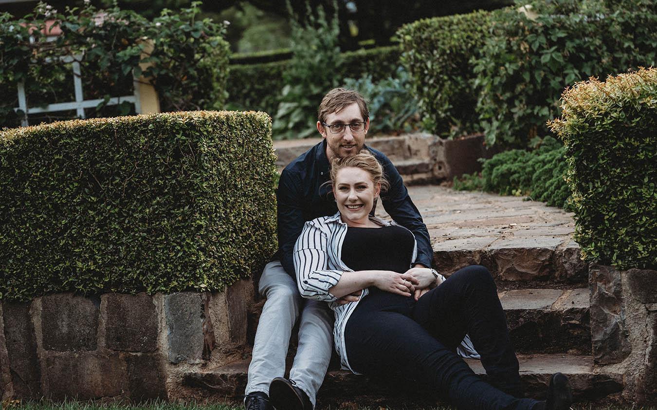 Engagement Photography - couple cuddling on steps in park