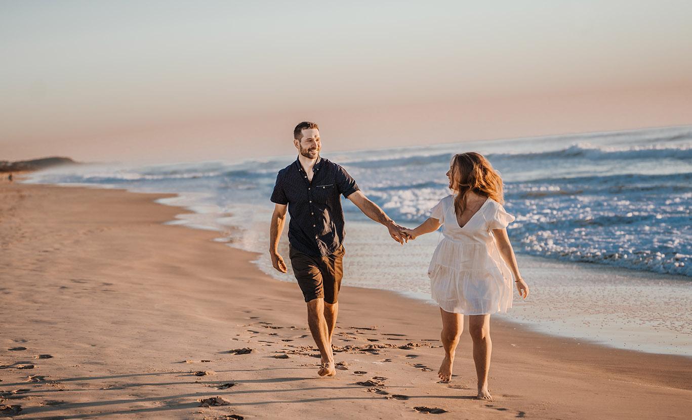 Engagement Photography couple holding hands on beach at sunset