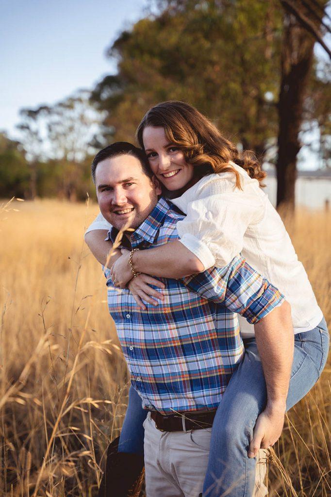 Engagement Photography - couple in field, fiance being carried