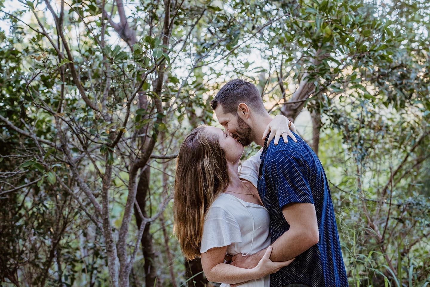 Engagement Photography - couple kiss among trees