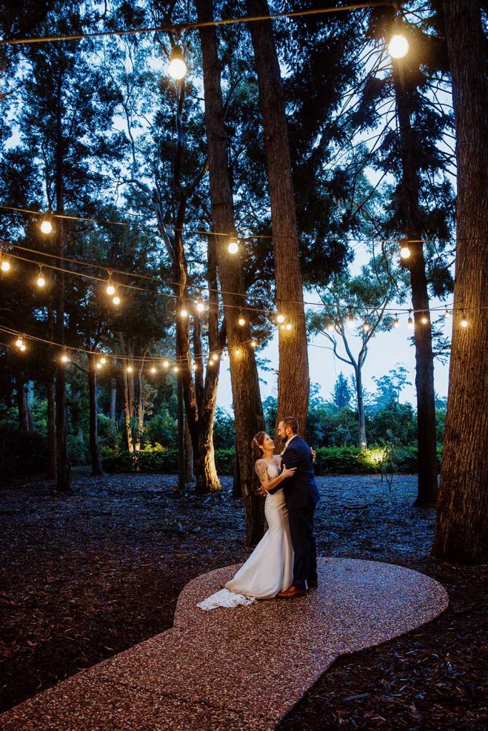 Wedding Photography - Bride and Groom embracing under lights