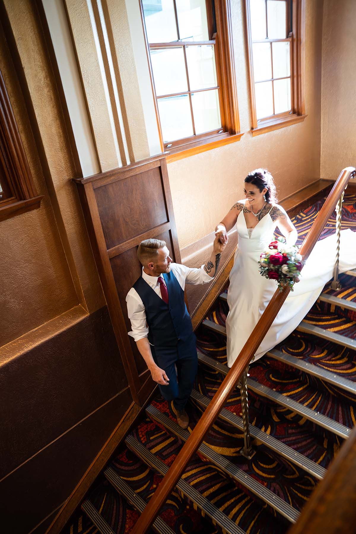 Wedding Photography - Groom escorting bride down grand stairs