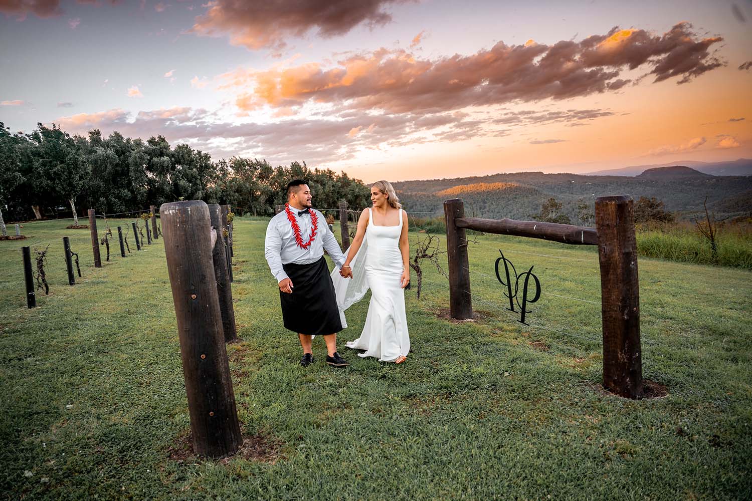 Wedding Photography - Bride and Groom walking through vineyard