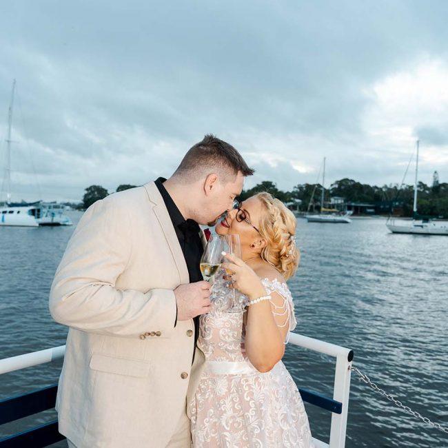 Destination Wedding Photography - Bride and Groom kissing on boat