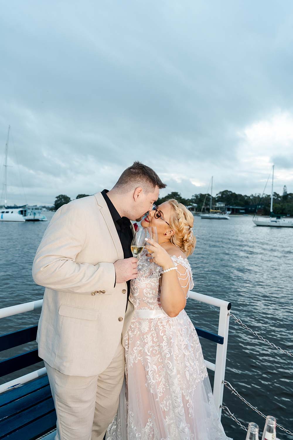 Destination Wedding Photography - Bride and Groom kissing on boat