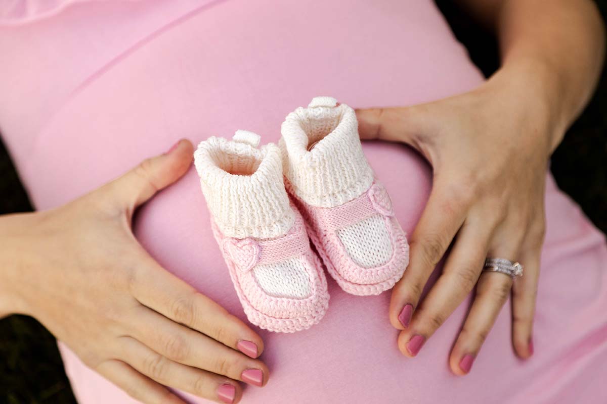 Maternity Shoot Photography - Baby Shoes on baby bump closeup