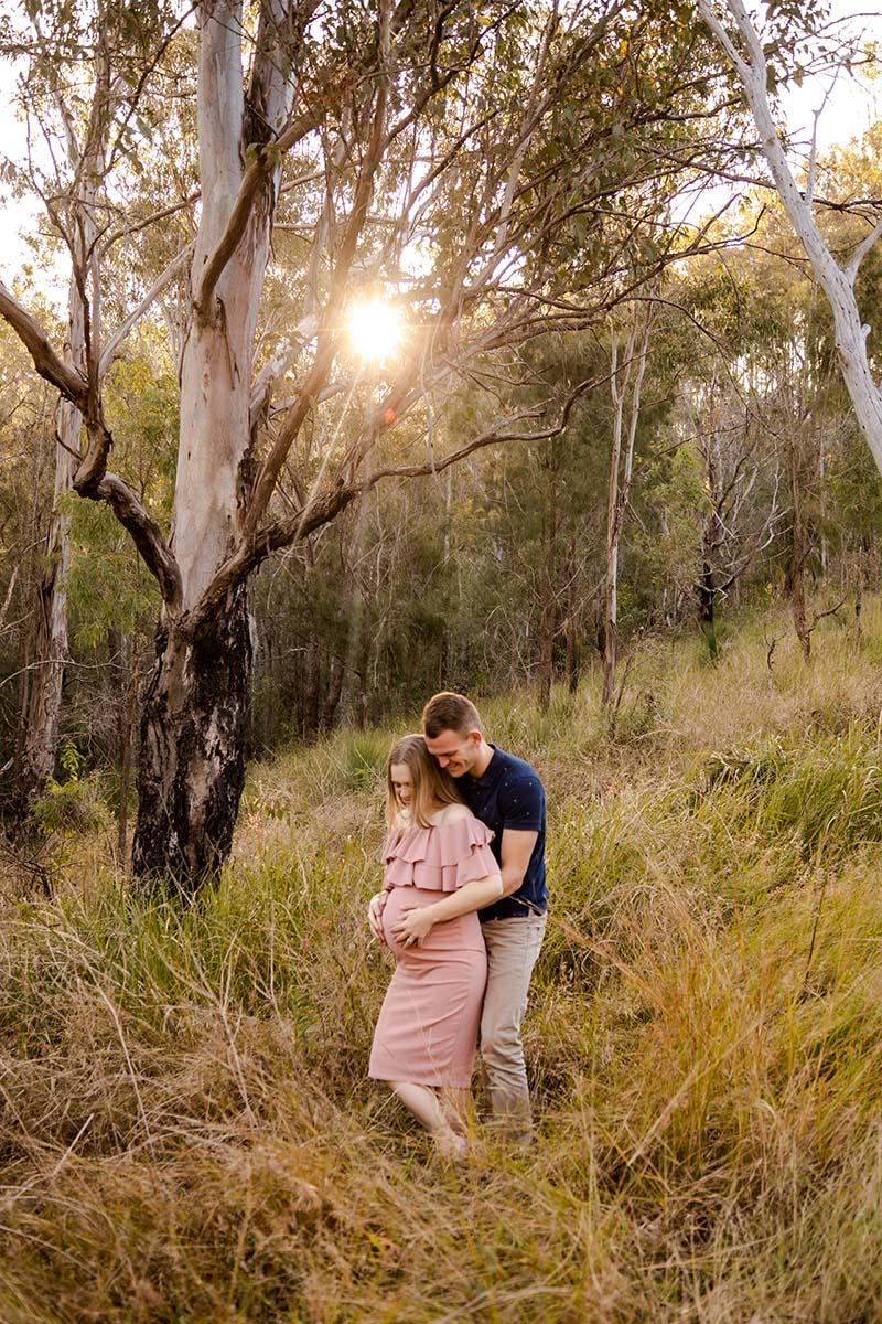Maternity Shoot Photography - couple embracing outdoors among trees