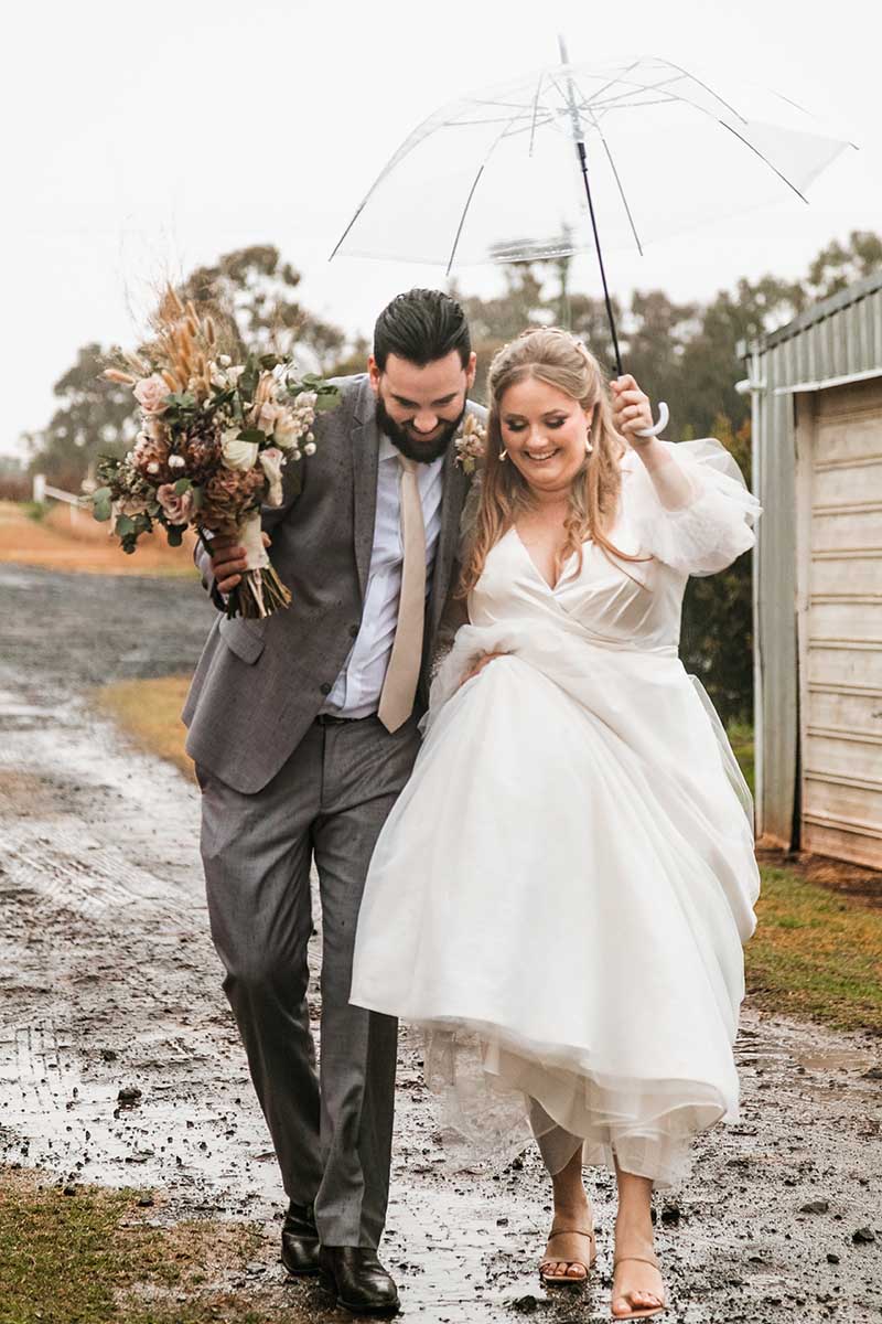 Wedding Photography - Bride and Groom walking in rain
