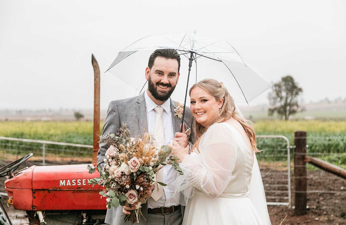 Wedding Photography - Bride and groom standing under umbrella