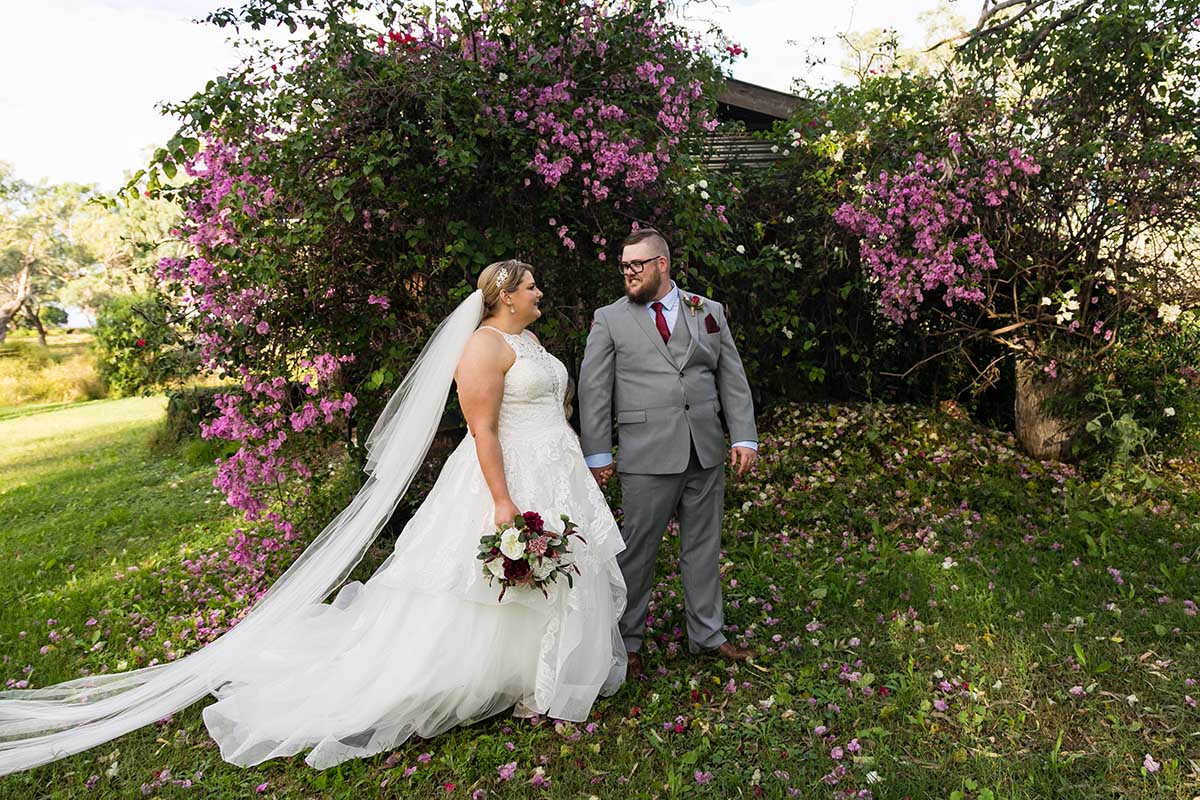 Wedding Photography - Couple in front of bush with beautiful flowers