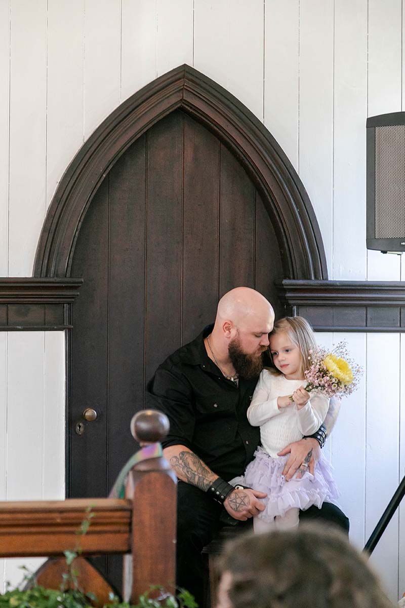Wedding Photography - wedding guest dad holding daughter