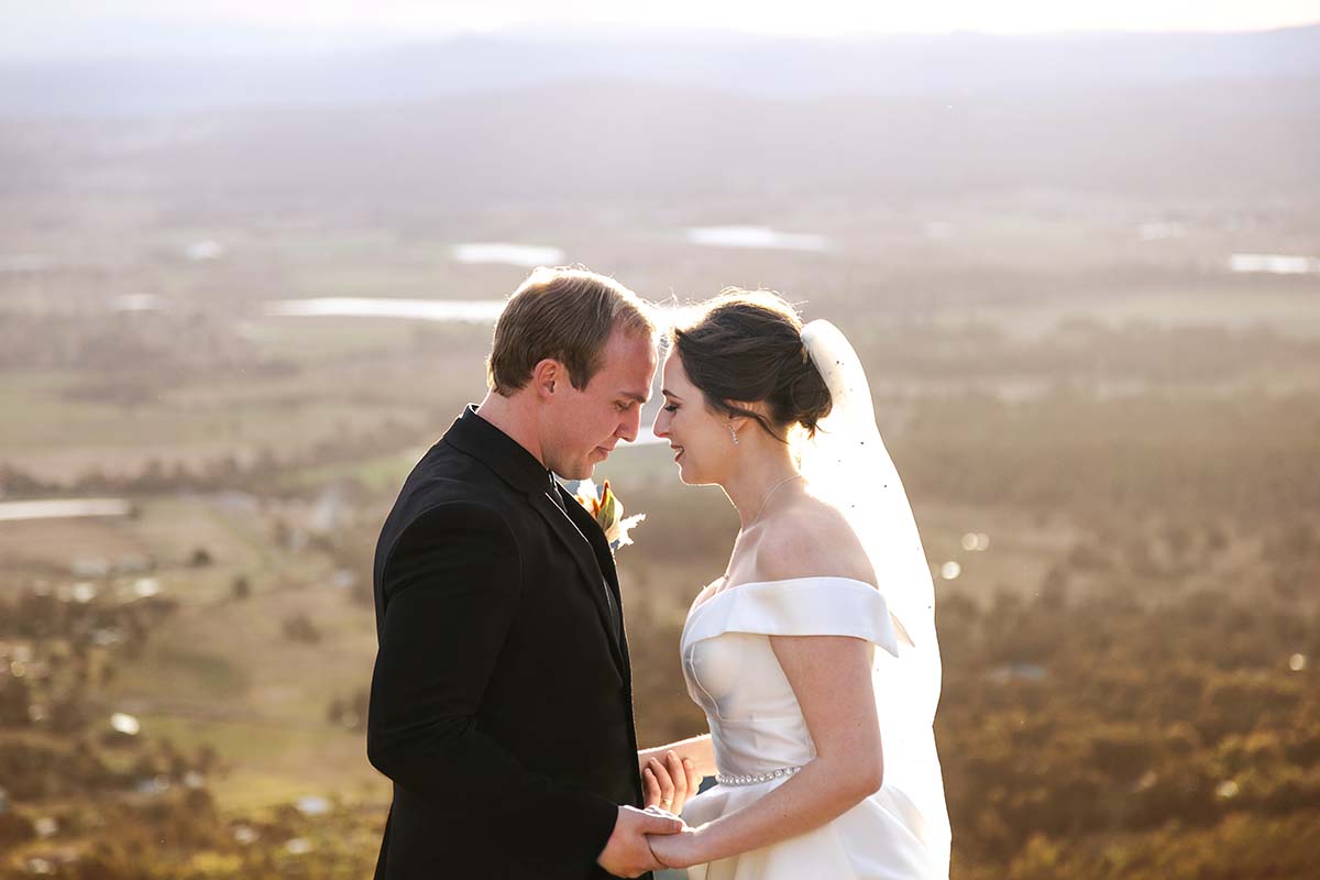 Wedding Photography – Bride and groom embracing in front of landscape views