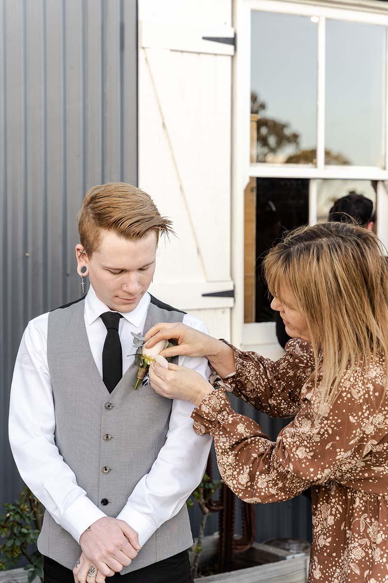 Wedding Photography - pinning flower to groomsmens vest