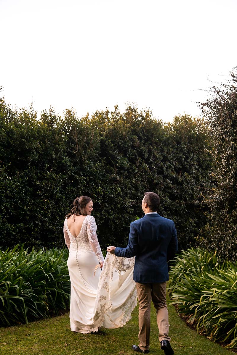Wedding Photography - bride and groom walking through garden