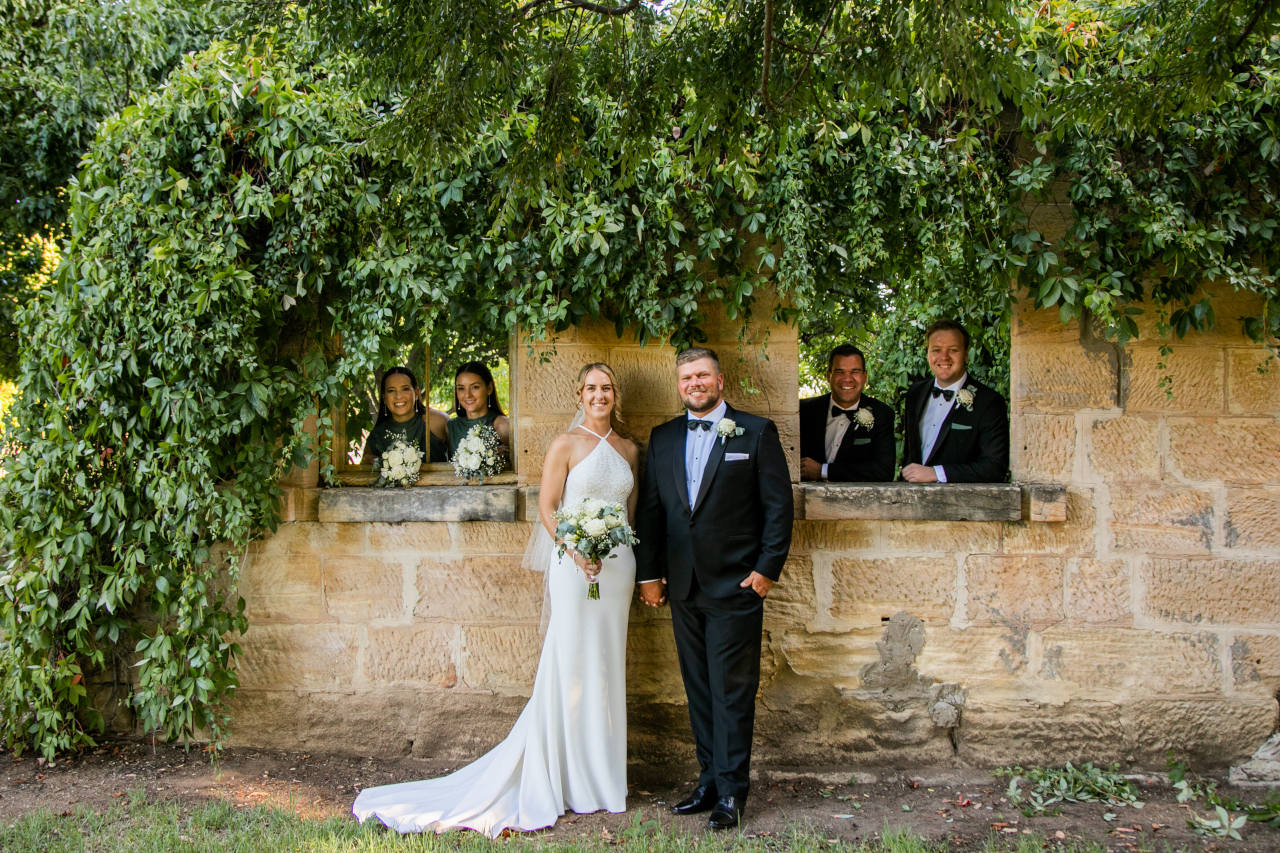 Tim and Natalia Exelby Bride groom best men and bridesmaids posing in overgrowth