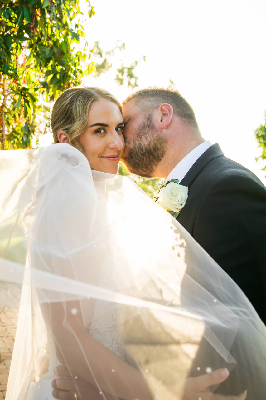 Tim and Natalia Exelby Groom kissing brides cheek