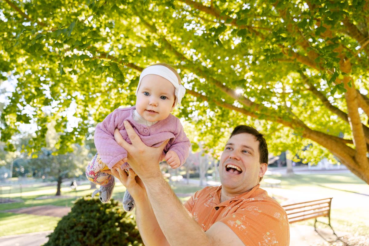 Family Photography dad holding baby in air