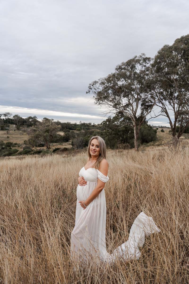 Maternity Photography holding belly in field