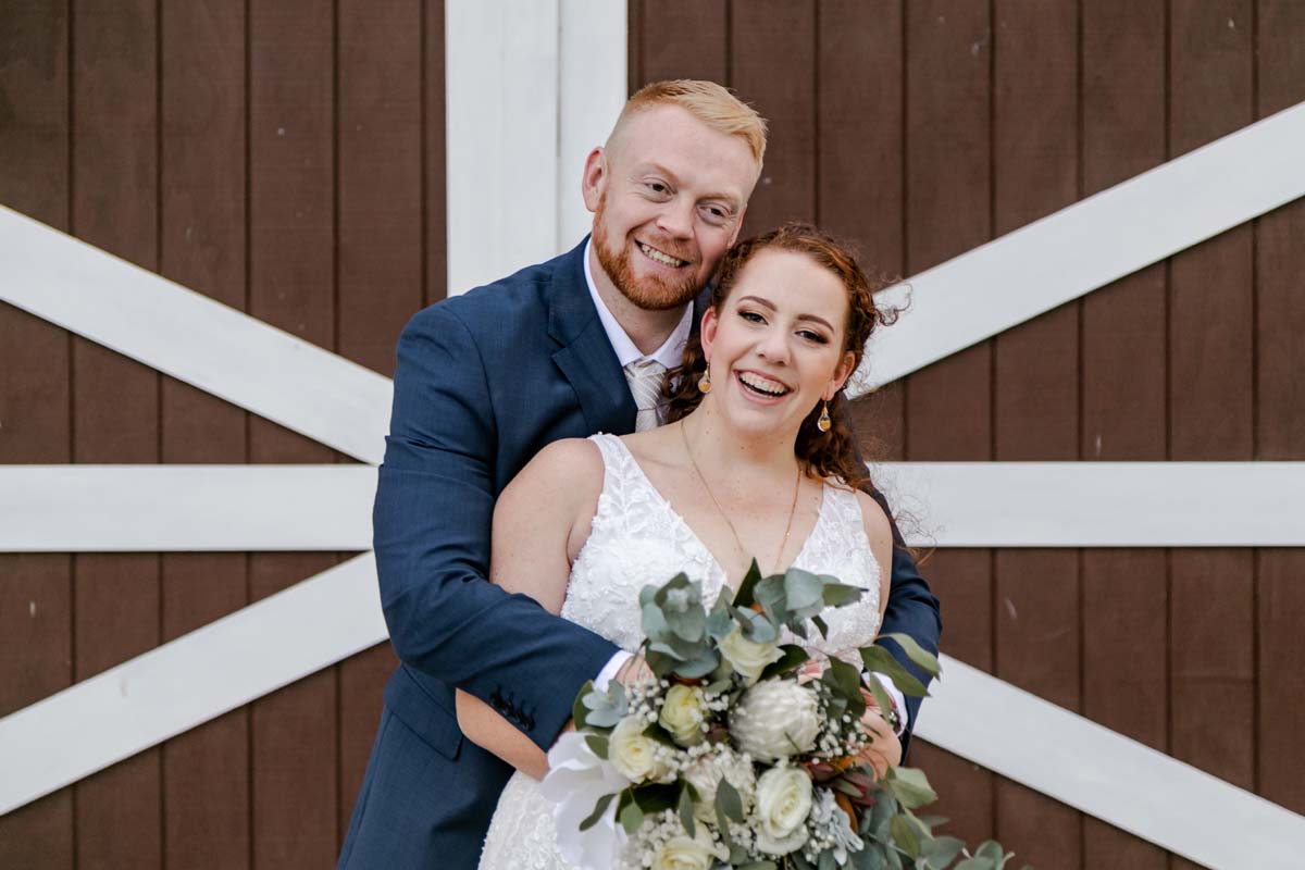 Wedding Photography bride and groom in front of rustic barn door
