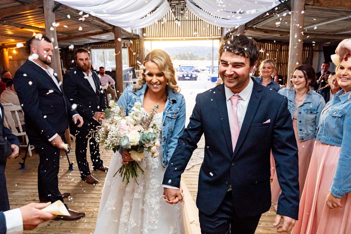 Wedding Photography bride and groom walking through confetti