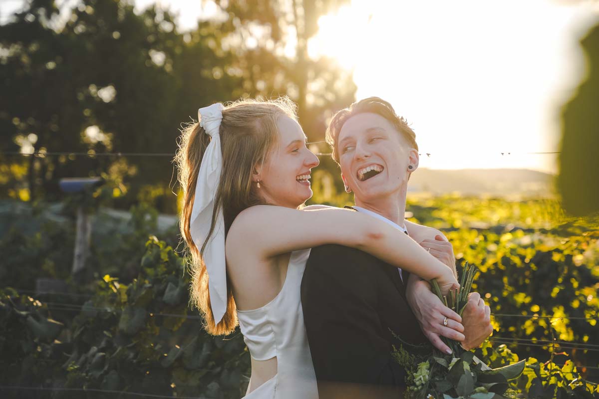 Wedding Photography bride holding groom while laughing